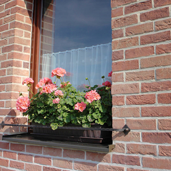 Jednoduchý kovaný držiak kvetináčov na okne rodinného domu - okenná zábrana na kvety