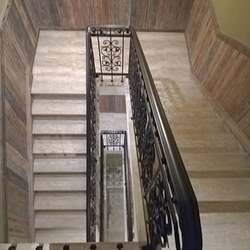 Pohľad na schodiskové zábradlie zhora - kované zábradlie v interiéri penziónu