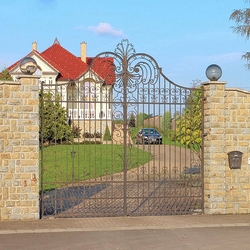 An exclusive wrought iron gate and fence in a family villa - A forged gate in historical style