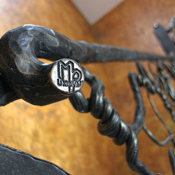 Umelecké zábradlie - ručne kované interiérové zábradlie na schodisko - Korene - detail loga UKOVMI